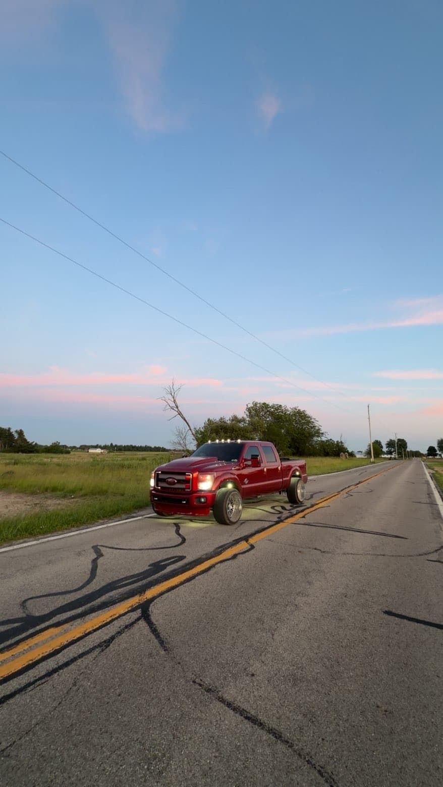 Custom red Ford Super Duty on a country road at sunset — TP Customs LLC build, Saint Paris Ohio