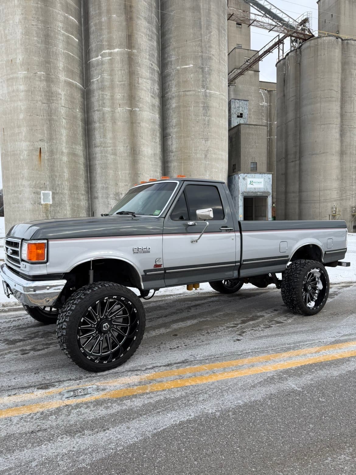 Lifted grey OBS Ford F-250 at grain silos — TP Customs LLC